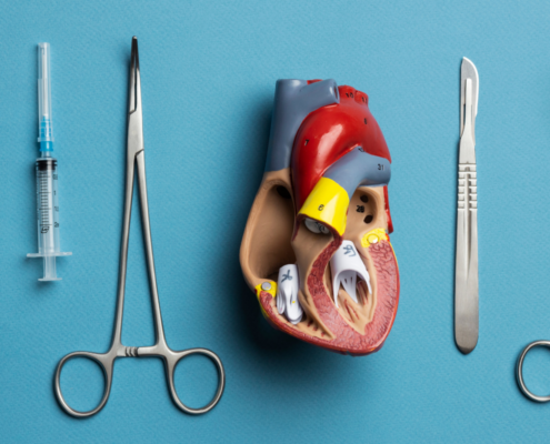 Num fundo azul claro, há instrumentos simples de cirurgia cardiovascular um do lado do outro e no centro temos um objetivo anatômico de um coração com transcateter