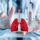 Foto com aproximação nas mãos de um médico sentado frente a uma projeção digital do pulmão e dados do paciente para representar os procedimentos de embolia pulmonar