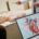 Imagem fechada de uma aula na especialização em cardiologia. No canto direito temos uma tela de notebook com a imagem de um coração e a descrição de sua anatomia. Ao fundo, um pouco desfocado, temos a imagem de um boneco para sessões práticas com um professor apontado para ele