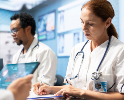 Imagem de dois médicos, um homem negro e uma mulher com cabelos ruivos, estudando para representar as especializações do Ensino InCor